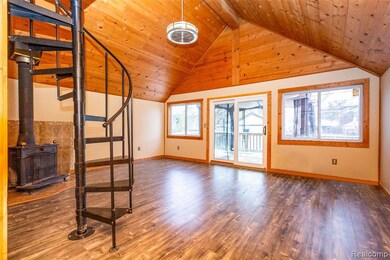 Unfurnished living room with a wood stove, wood finished floors, high vaulted ceiling, and a wooden ceiling with exposed beams