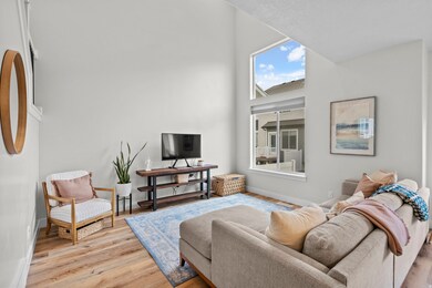 Living room featuring a towering ceiling and light wood finished floors
