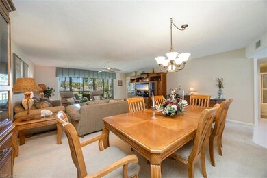 Dining space with baseboards, a chandelier, a textured ceiling, visible vents, and light carpet