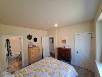Carpeted bedroom featuring ensuite bathroom