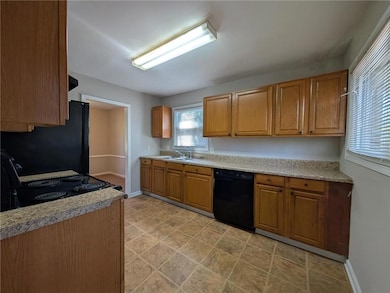 Kitchen featuring baseboards, light countertops, b