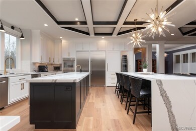 Kitchen featuring coffered ceiling, white cabinetr
