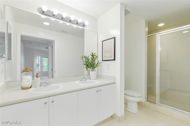 Full bath featuring double vanity, a stall shower,