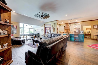 Living room with ceiling fan, pool table, hardwood