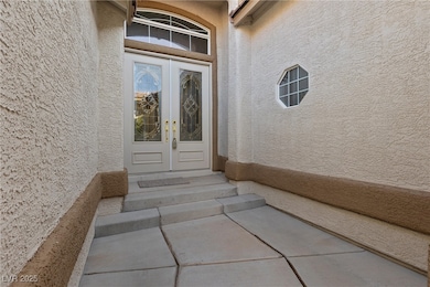 Doorway to property with stucco siding and french