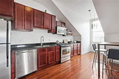 Expansive kitchen with stainless steel appliances including dishwasher and microwave