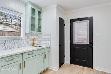 Kitchen with sink, green cabinets, ornamental mold