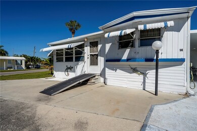 View of front of house, light post, driveway, and wheelchair ramp