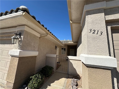 Entrance to property with stucco siding, a tile roof, a gate, fence, and a garage