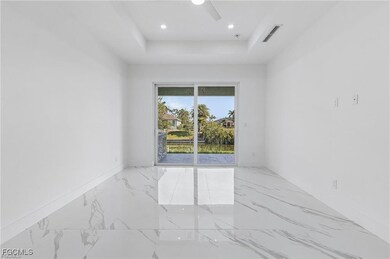 Empty room with marble tiled floors, a raised ceil
