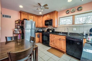 Kitchen featuring black appliances, light tile patterned flooring, brown cabinets, decorative backsplash, and recessed lighting