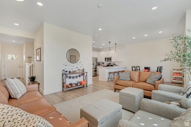 Living area with light wood-type flooring and recessed lighting