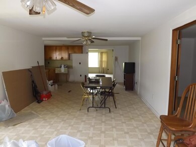 The kitchen opens to a large den with French doors to side porch and back patio. 