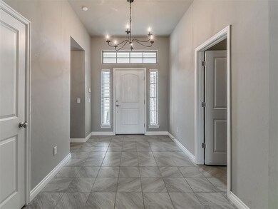 Entryway with a chandelier and light tile floors