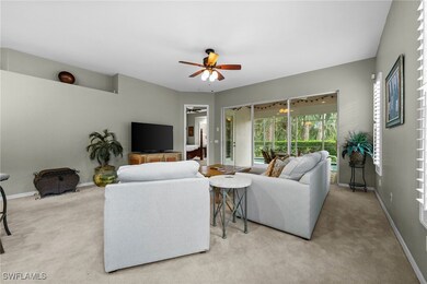 Carpeted living room with ceiling fan