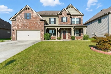 Craftsman house with brick siding, a porch, concrete driveway, and a front lawn