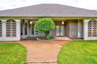 Property entrance with a yard, brick siding, and a shingled roof