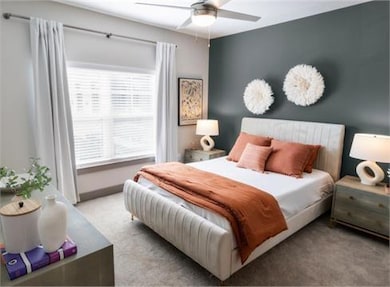 Carpeted bedroom featuring ceiling fan