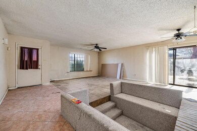 Living room featuring ceiling fan, light tile patt
