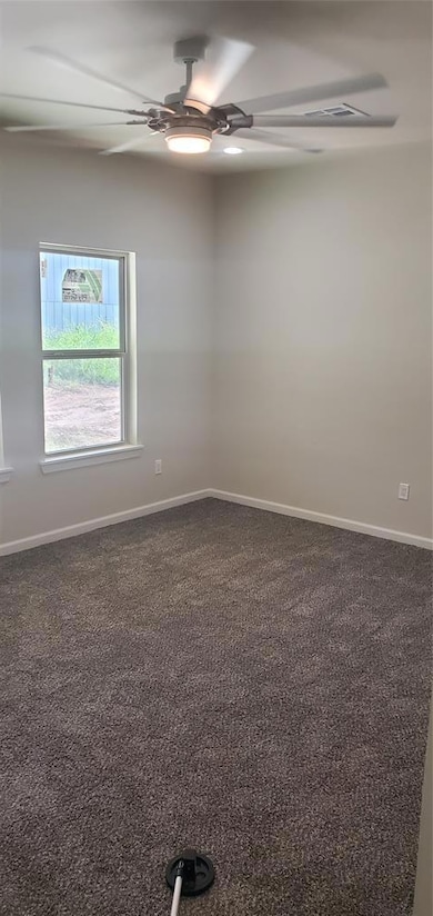 Spare room featuring a ceiling fan and carpet