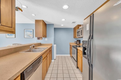 Kitchen with sink, light tile patterned flooring, 