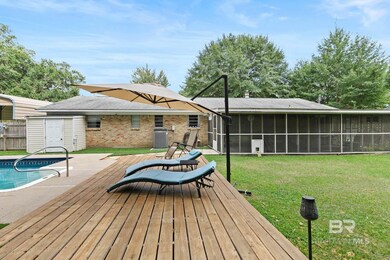 Deck featuring a lawn, a patio, and a sunroom