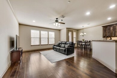 Living area with crown molding, dark wood-type flooring, a ceiling fan, a chandelier, and recessed lighting