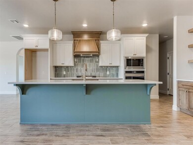 Kitchen with premium range hood, backsplash, stain