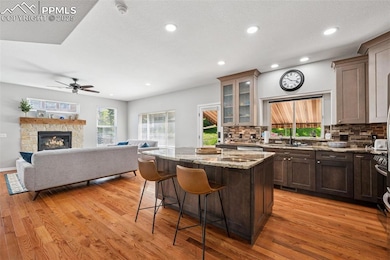 Kitchen featuring a breakfast bar, decorative backsplash, light wood-style floors, and recessed lighting