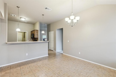 Kitchen with tile flooring, a chandelier, pendant lighting, and vaulted ceiling