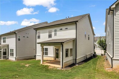 Rear view of house with a patio and a yard