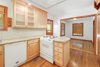 Kitchen featuring white appliances, light wood-st