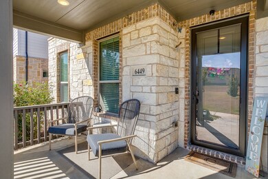 Doorway to property featuring a porch, stone siding, and brick siding