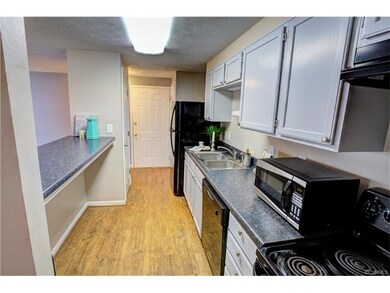 Updated galley kitchen with pretty gray cabinets, 