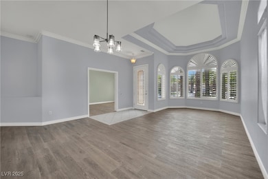 Spare room with a chandelier, wood finished floors