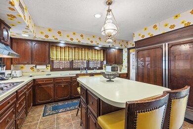 Kitchen featuring a textured ceiling, dark tile pa