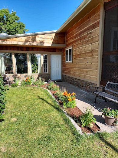 Doorway to property featuring a lawn