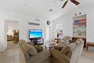 Living room featuring lofted ceiling, light tile p
