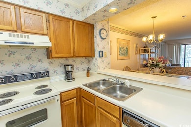 Kitchen with white electric stove, wallpapered walls, exhaust hood, a sink, and light countertops