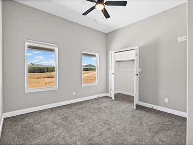 Unfurnished bedroom with carpet floors, a closet, and ceiling fan