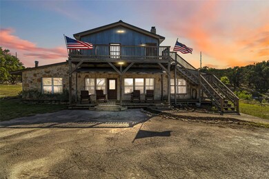View of front facade with a wooden deck and stairs