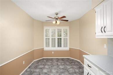 Unfurnished dining area with dark tile floors, ceiling fan, and a textured ceiling