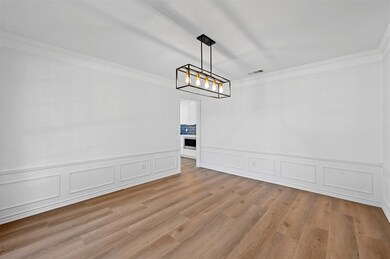 Unfurnished living room with crown molding, hardwo