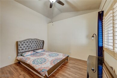 Bedroom featuring wood finished floors, lofted cei