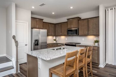 ***This photo was taken from a previously built Hemingway townhouse**  Open Kitchen with Quartz and Beveled Tile Backsplash Included.