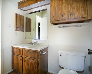 Half bathroom featuring toilet, baseboards, and va