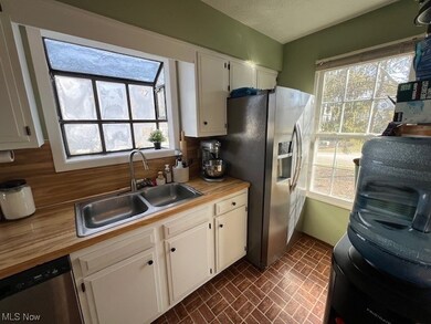 Kitchen featuring a healthy amount of sunlight, sink, and white cabinets