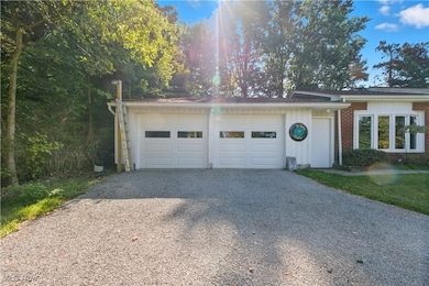 View of front facade featuring brick siding, driveway, and an attached garage