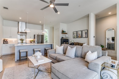 Living room featuring ceiling fan and light hardwood / wood-style flooring