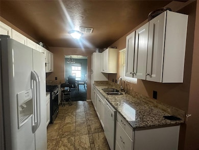 Kitchen featuring white appliances, white cabinets